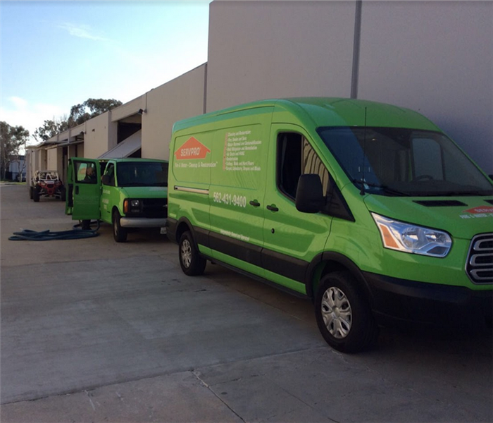 a SERVPRO truck and van parked by an office